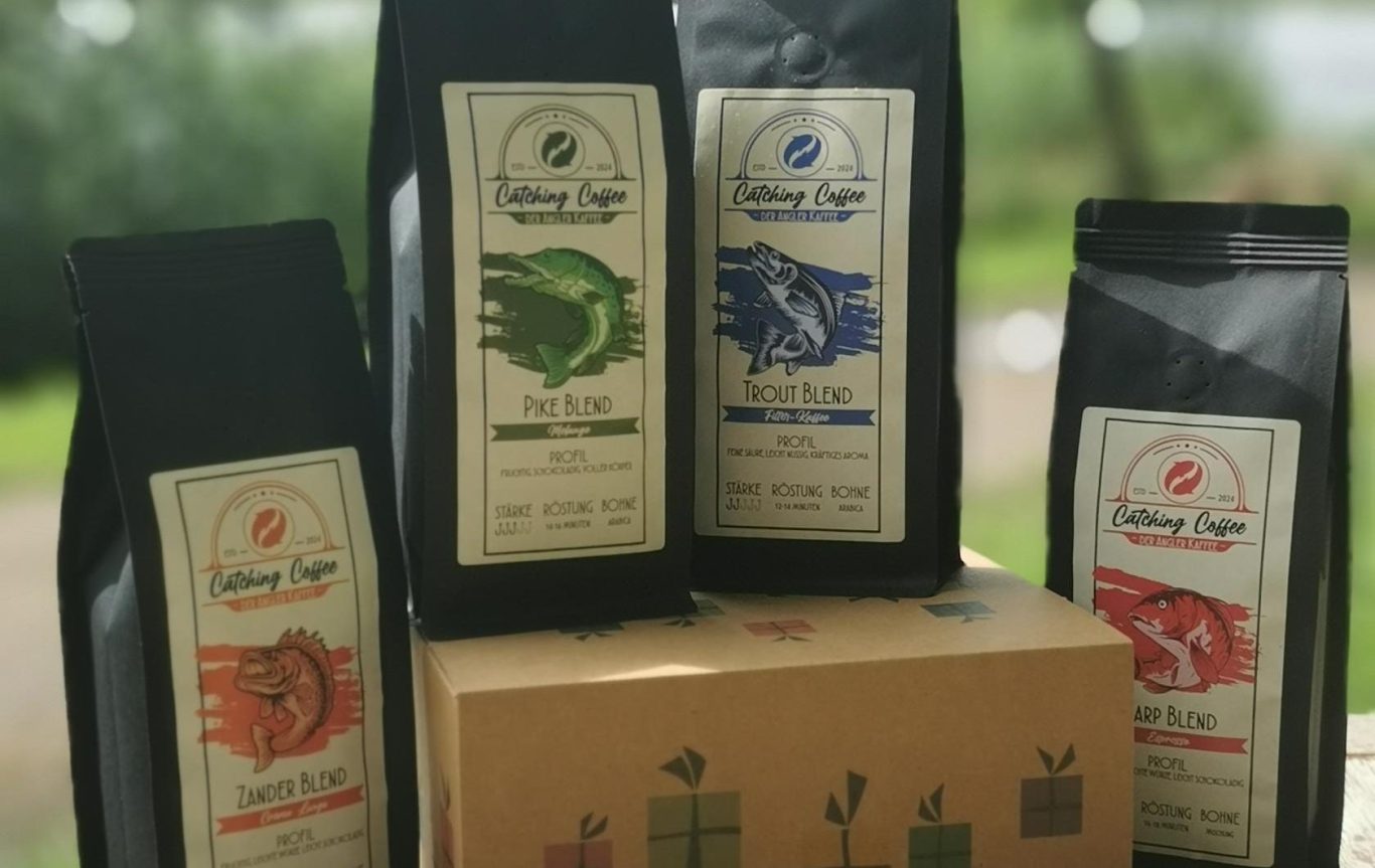 Vier Kaffeetüten in verschiedenen Farben stehen um eine geschenkte Box in der Mitte.